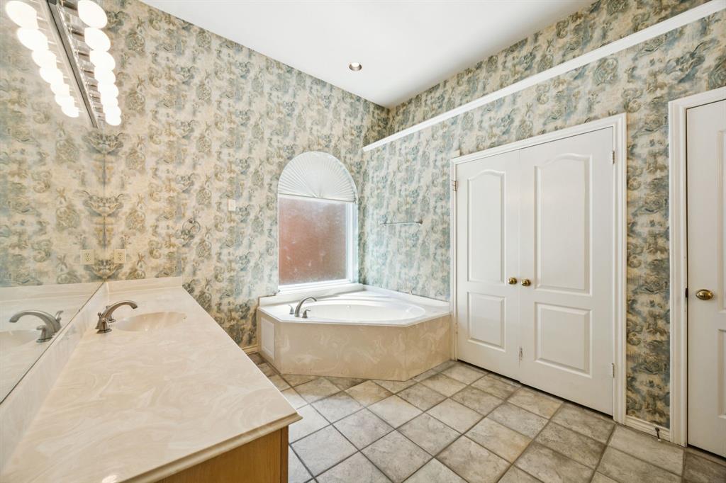 2604 Spring Lake Drive Richardson, TX 75082 - Photo 18 of 34 a bathroom with a tub a toilet and a shower