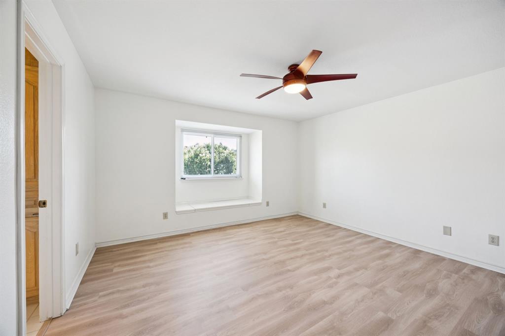 2604 Spring Lake Drive Richardson, TX 75082 - Photo 23 of 34 an empty room with wooden floor and ceiling fan