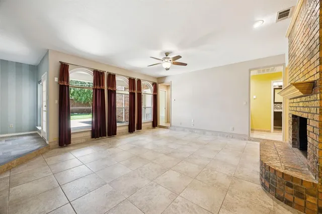 a view of an empty room with a fireplace and a window