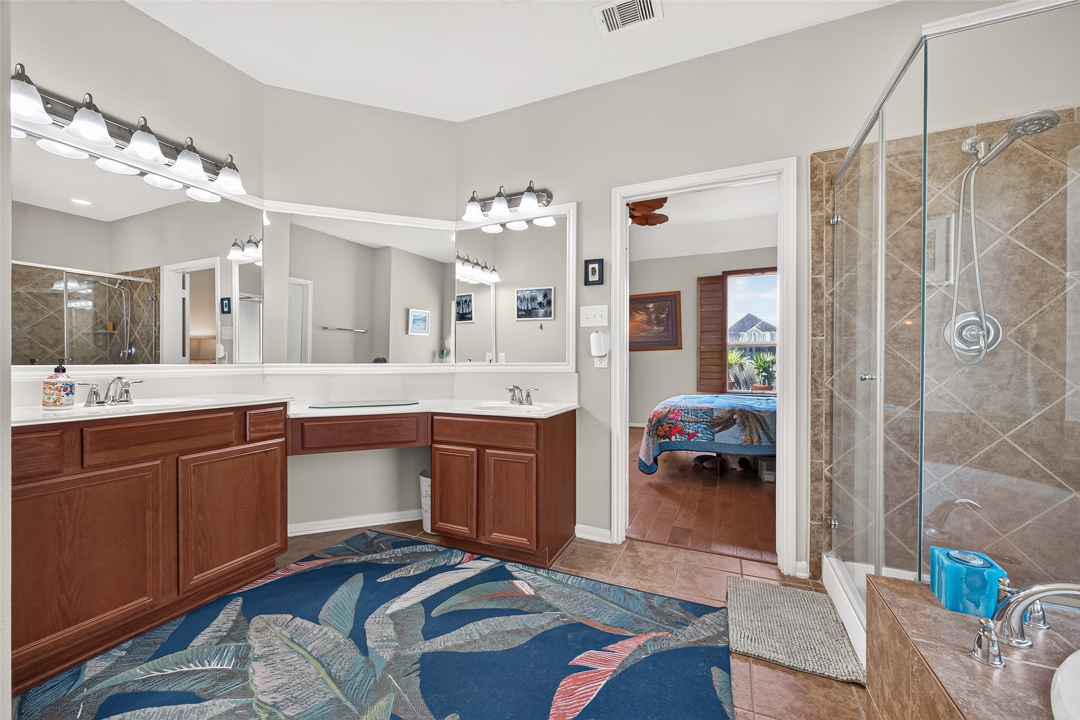 4910 Culver Lane Rosenberg, TX 77471 - Photo 35 of 50 Your primary en-suite bathroom features a spacious double vanity with cultured marble countertops, ample lighting, a seamless, glass-enclosed shower, and large soaking tub. The design includes a stylish tile floor.