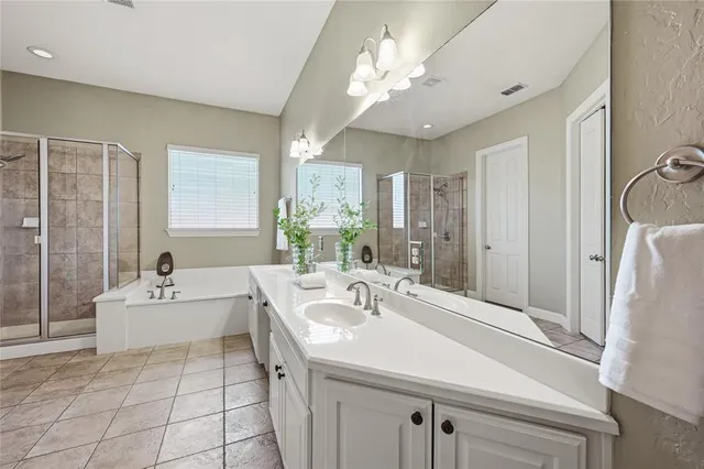a spacious bathroom with a sink a large mirror and shower