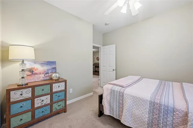 a bedroom with a bed and a lamp on dresser