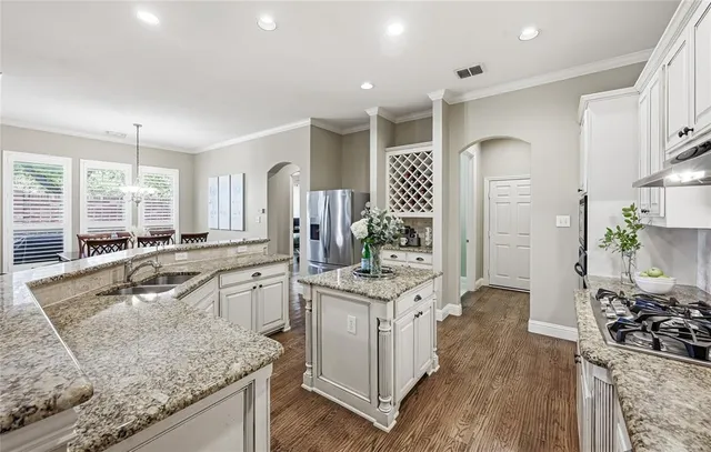 a kitchen with stainless steel appliances granite countertop a sink stove and refrigerator