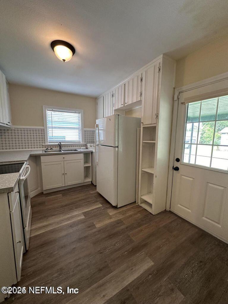 803 Crestwood Street Jacksonville, FL 32208 - Photo 7 of 14 a kitchen with a refrigerator a stove a sink and a window