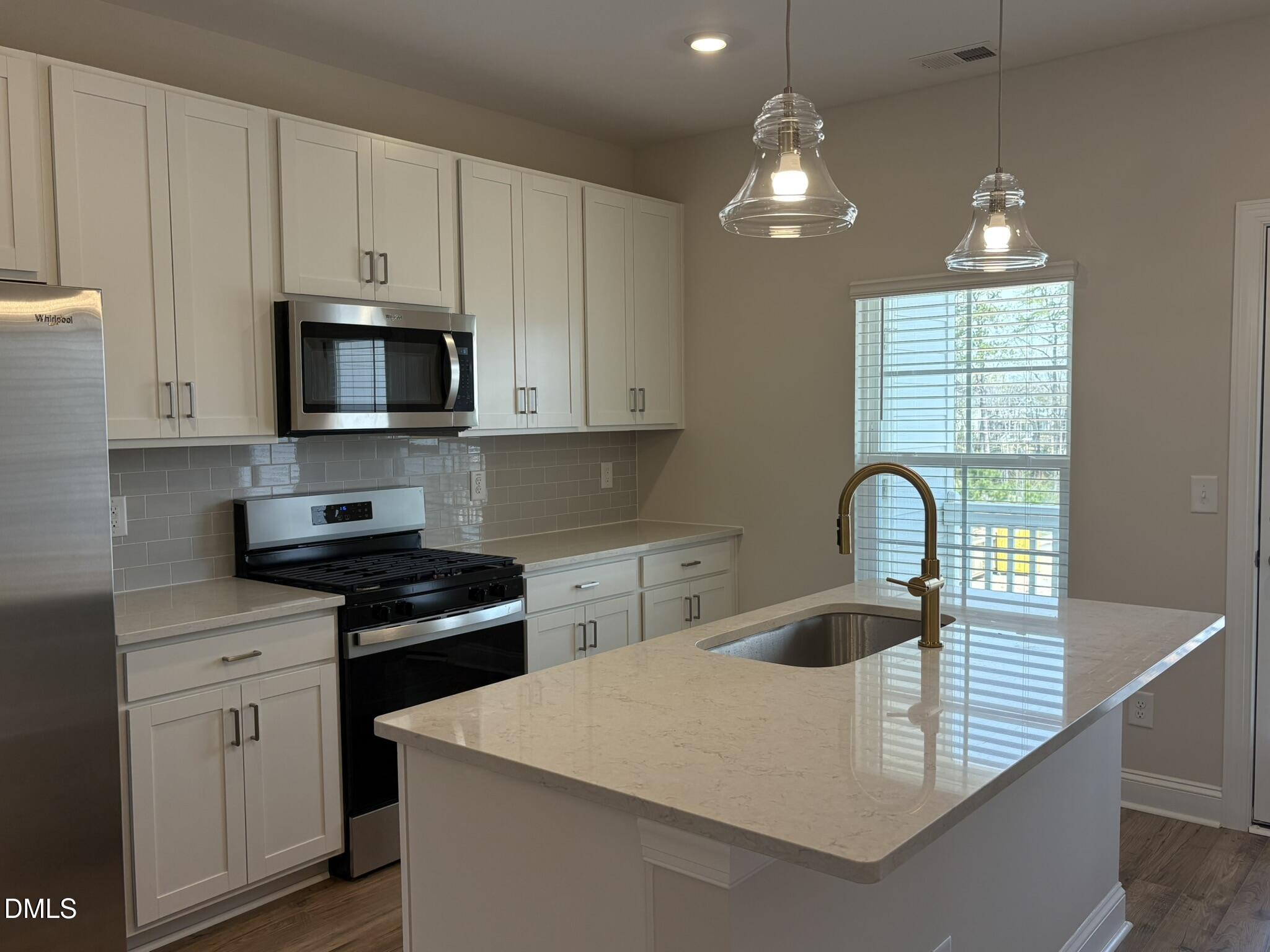 521 Forestville Road Wake Forest, NC 27587 - Photo 4 of 7 a kitchen with kitchen island granite countertop a sink a stove and cabinets