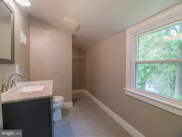 a bathroom with a sink a toilet and a window
