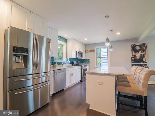 a kitchen with stainless steel appliances granite countertop a refrigerator and a stove top oven