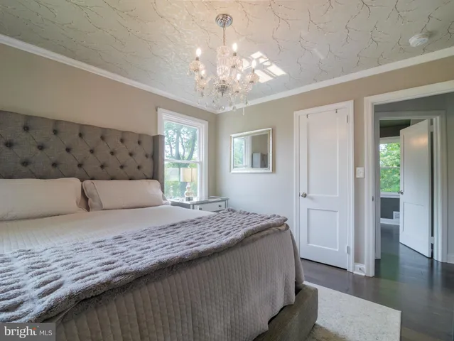 a bedroom with a large bed and a chandelier