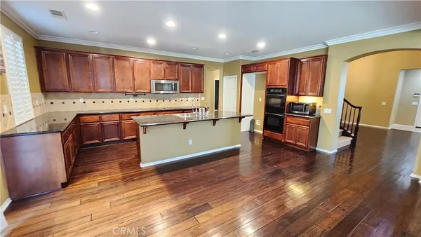 a kitchen with stainless steel appliances granite countertop a stove a sink and a refrigerator