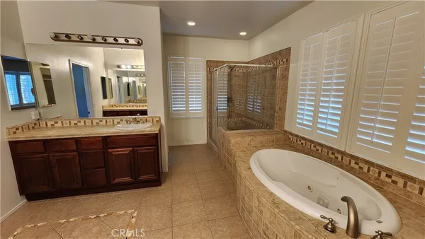 a bathroom with a tub sink and mirror