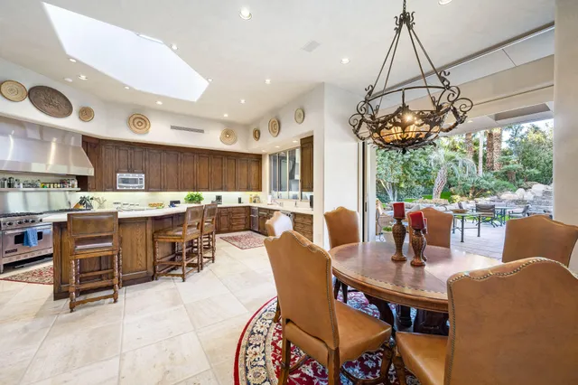 a dining room with stainless steel appliances kitchen island granite countertop a table and chairs