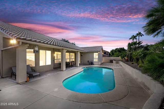 a view of a house with swimming pool and sitting area