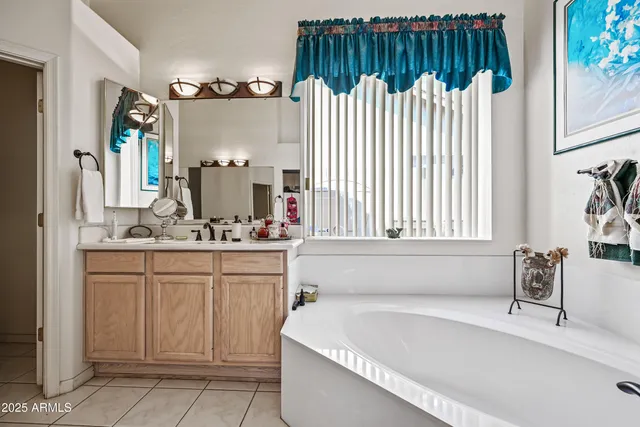 a large white kitchen with a sink large mirror and cabinets