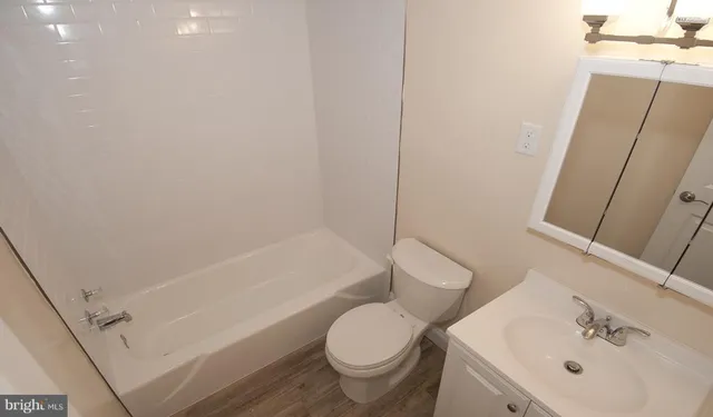 a white toilet sitting next to a bath tub