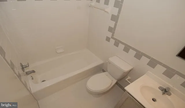 a white toilet sitting next to a bath tub