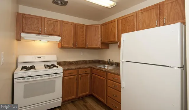 a kitchen with a refrigerator sink stove and cabinets