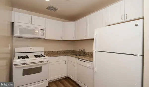 a kitchen with a refrigerator sink stove and cabinets