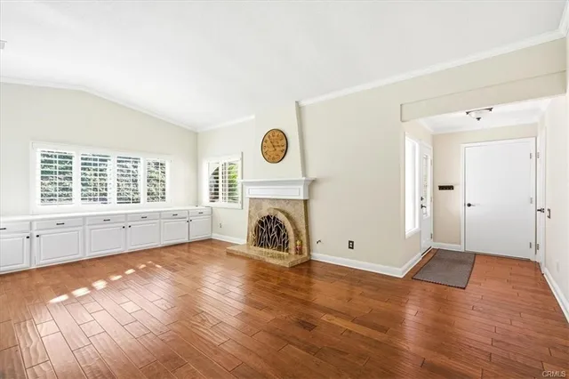 a view of empty room with wooden floor and fireplace