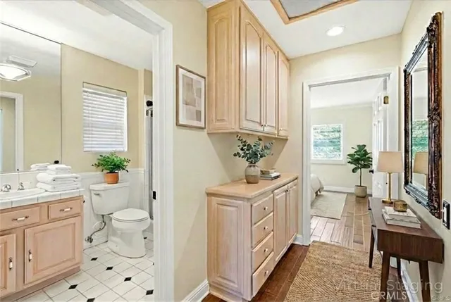 a spacious bathroom with a sink a toilet and a mirror