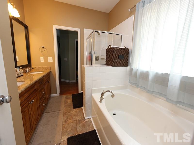 8417 Lunar Stone Place Raleigh, NC 27613 - Photo 8 of 15 a bathroom with a tub sink and mirror