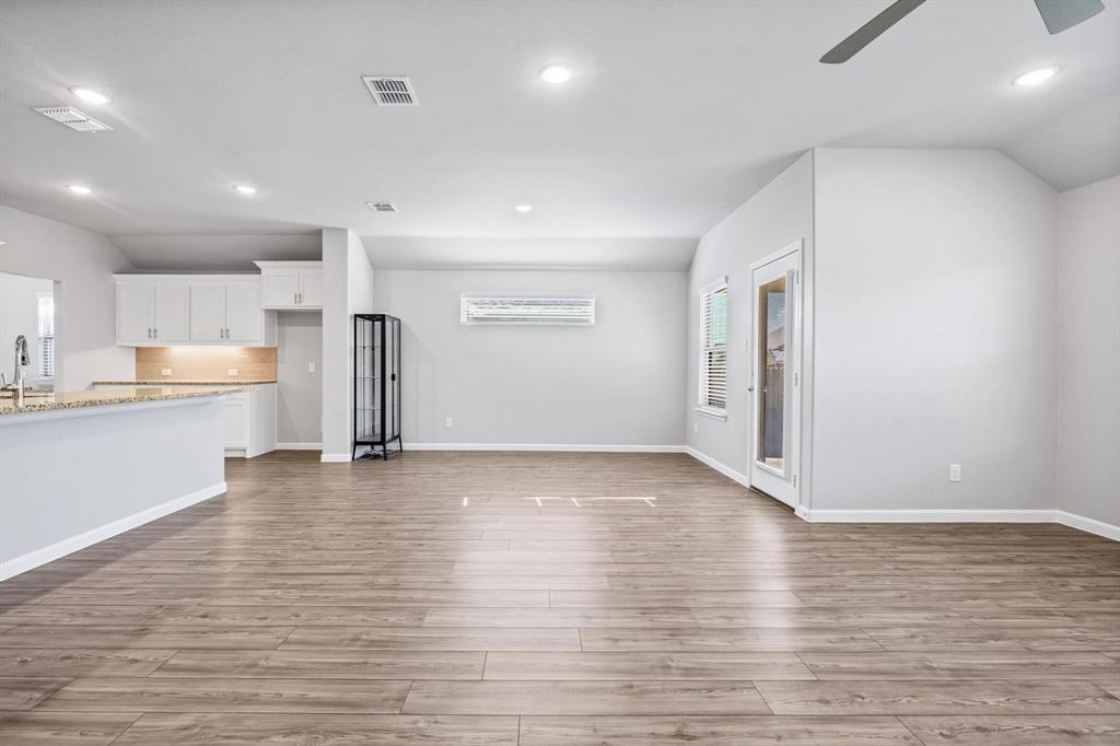 620 Shade Tree Way Princeton, TX 75407 - Photo 11 of 35 a view of an empty room with wooden floor and a window