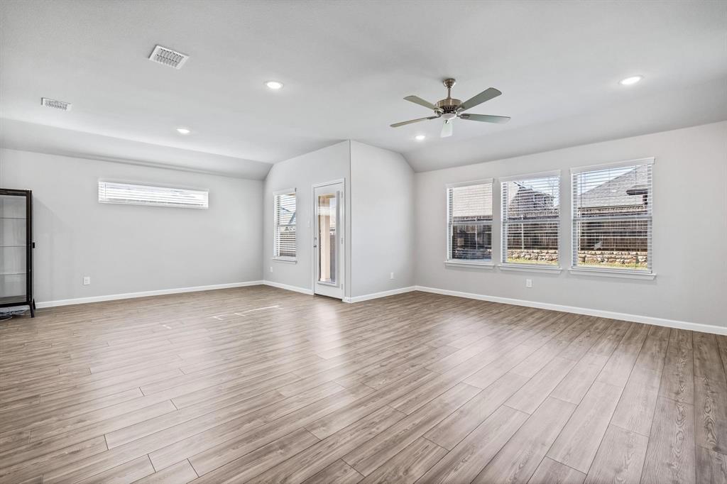 620 Shade Tree Way Princeton, TX 75407 - Photo 13 of 35 a view of an empty room with a window and wooden floor