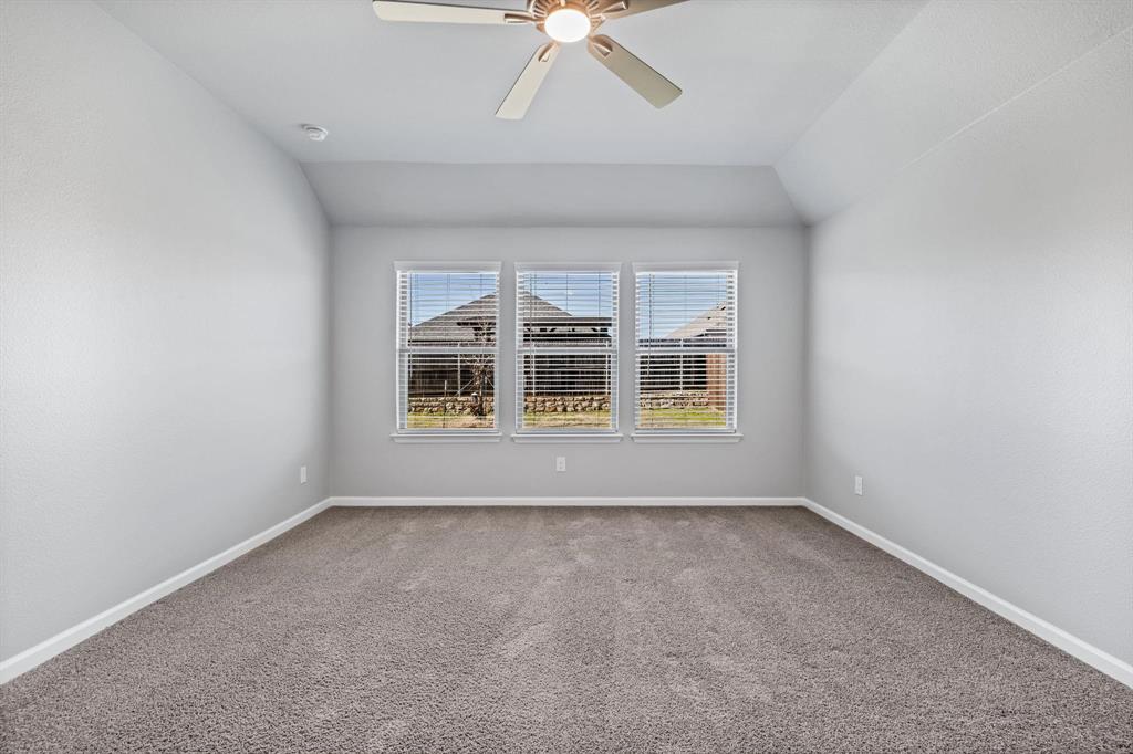 620 Shade Tree Way Princeton, TX 75407 - Photo 18 of 35 an empty room with chandelier fan and windows