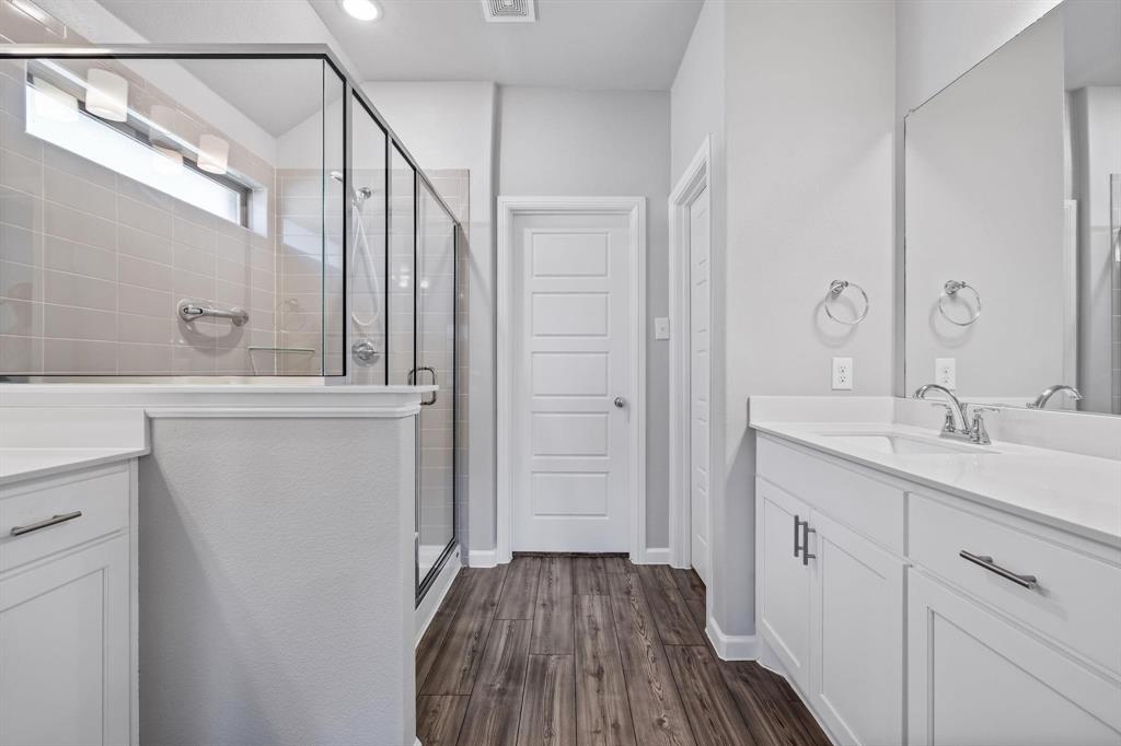 620 Shade Tree Way Princeton, TX 75407 - Photo 22 of 35 a bathroom with a sink a mirror and a shower