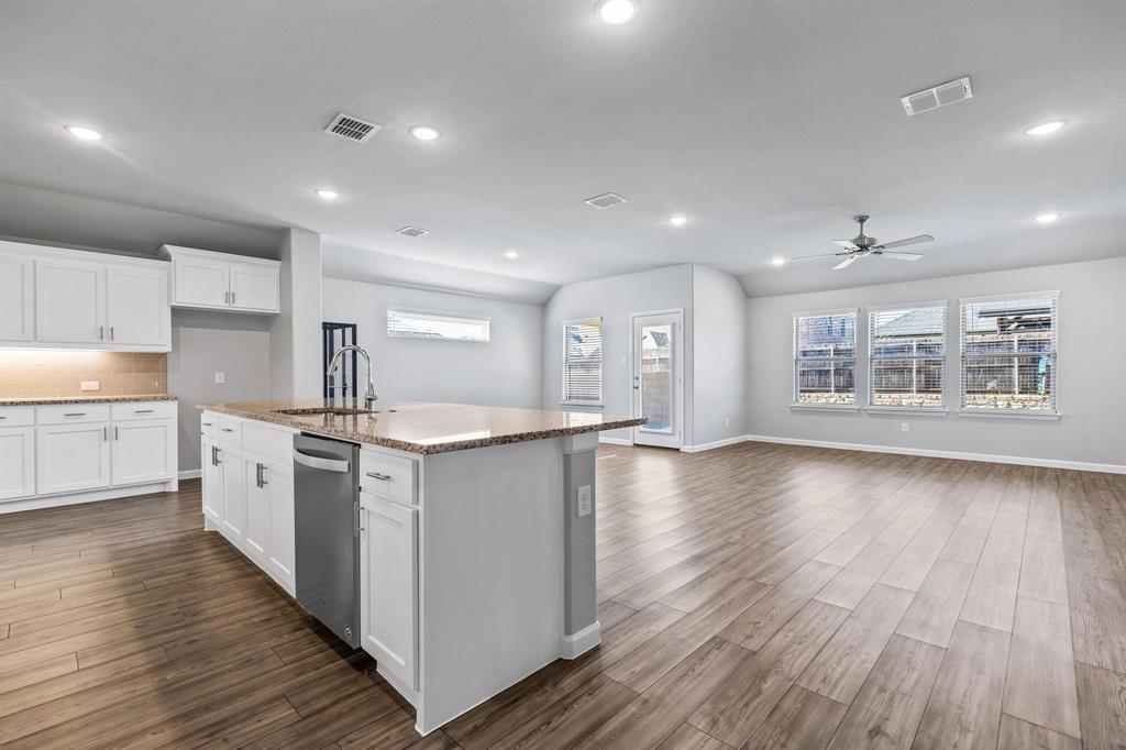 620 Shade Tree Way Princeton, TX 75407 - Photo 6 of 35 a kitchen with stainless steel appliances granite countertop a white cabinets and wooden floors