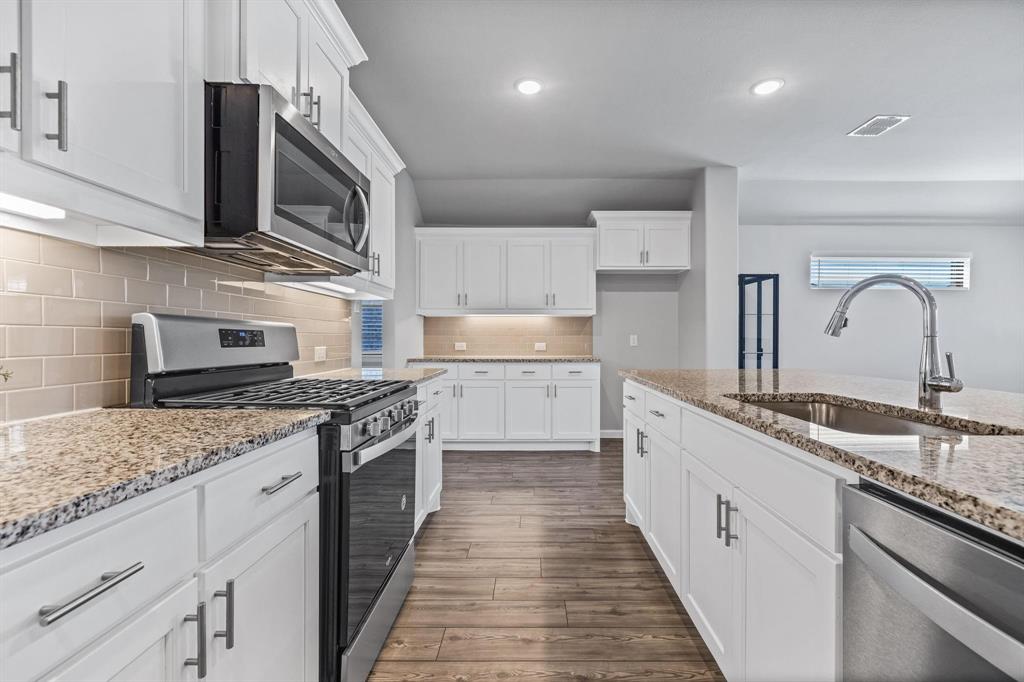 620 Shade Tree Way Princeton, TX 75407 - Photo 7 of 35 a kitchen with stainless steel appliances granite countertop a sink and stove top oven