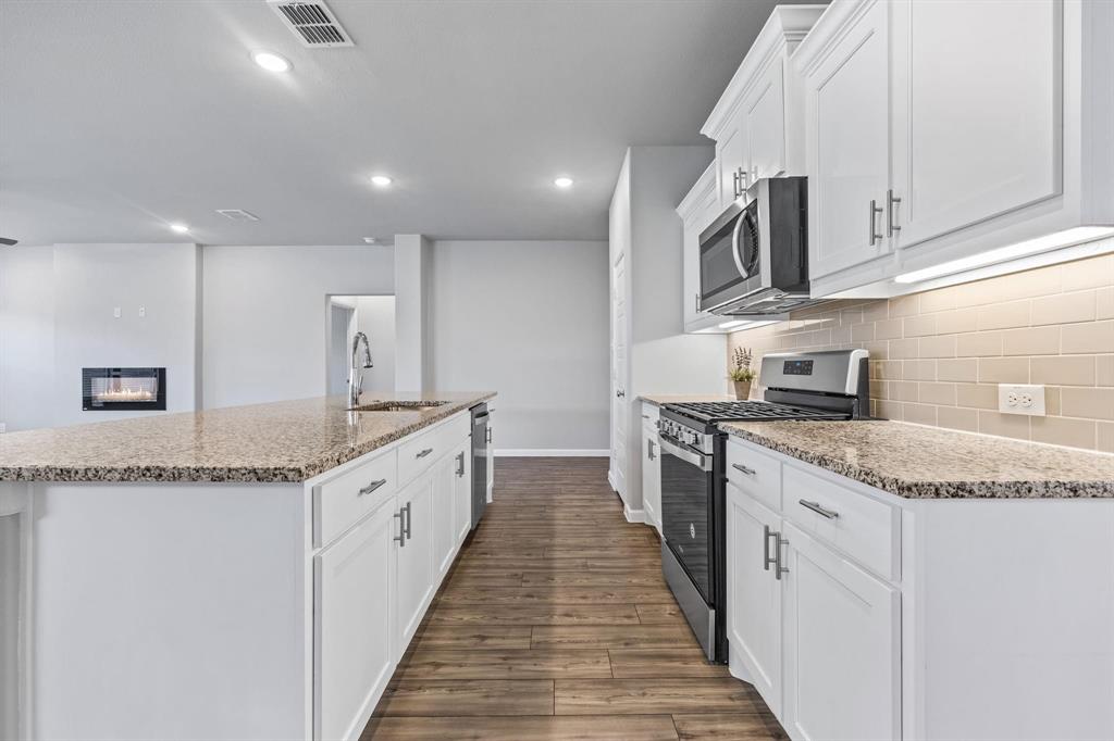 620 Shade Tree Way Princeton, TX 75407 - Photo 8 of 35 a large kitchen with granite countertop a sink and dishwasher a stove top oven with wooden floor