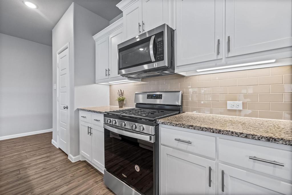 620 Shade Tree Way Princeton, TX 75407 - Photo 9 of 35 a kitchen with granite countertop cabinets stainless steel appliances and wooden floor