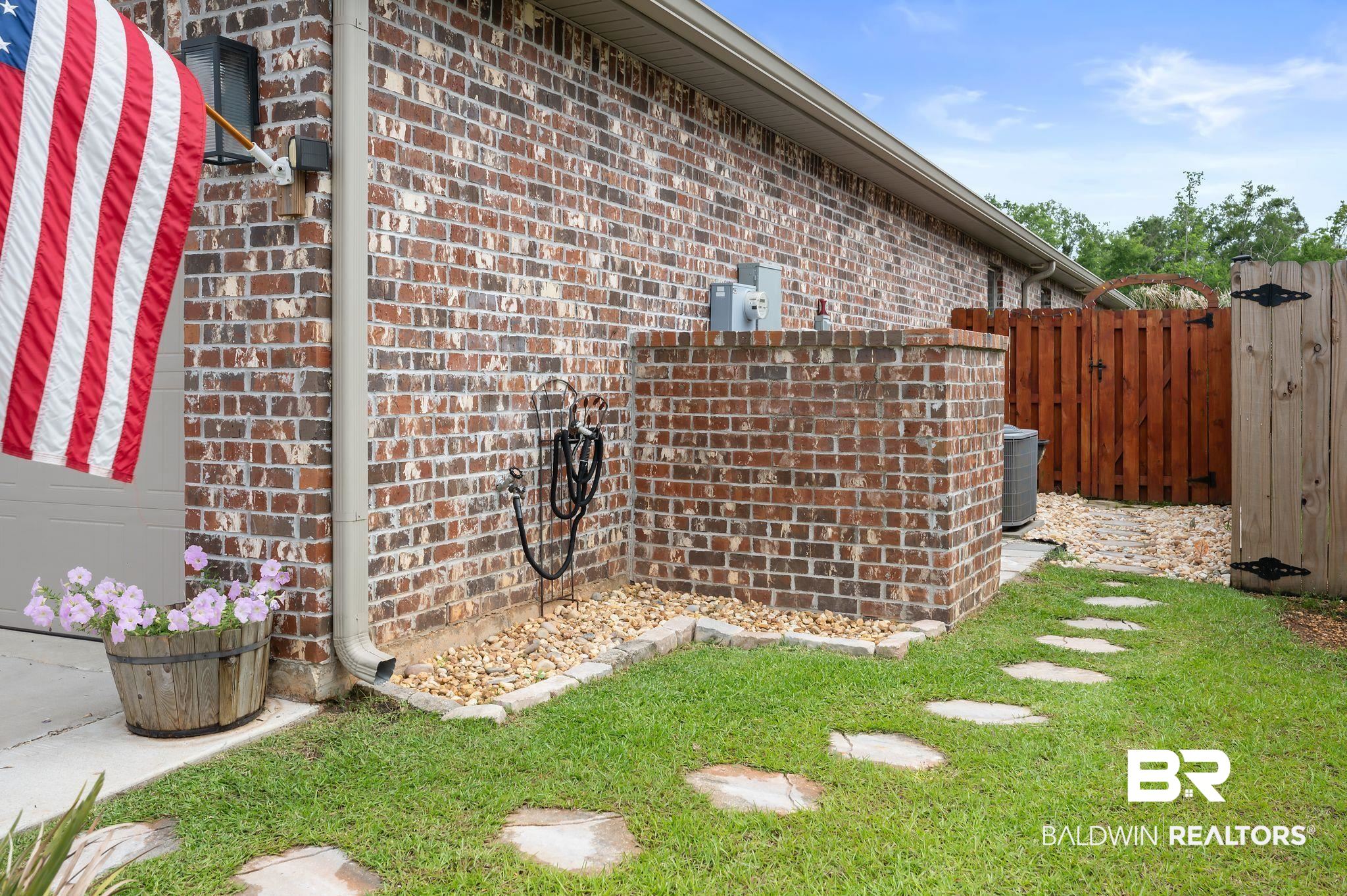 1165 Stella Road Foley, AL 36535 - Photo 41 of 42 View of property exterior featuring brick siding, a gate, fence, and central AC unit
