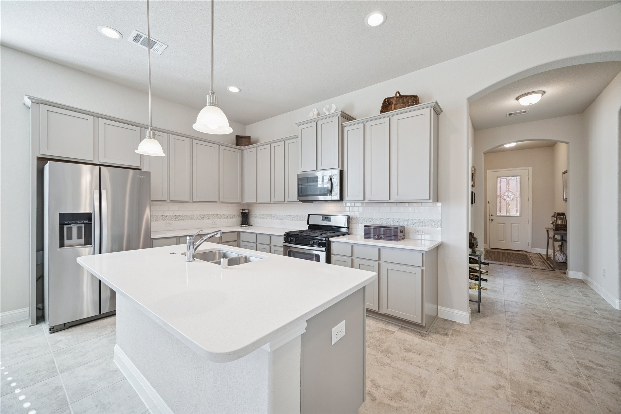 4615 Verbena Valley Way Spring, TX 77388 - Photo 4 of 25 From the modern kitchen, you can see back to the front door. Gas cooktop and plenty of quartz covered counter space make the home perfect for entertaining family or friends.
