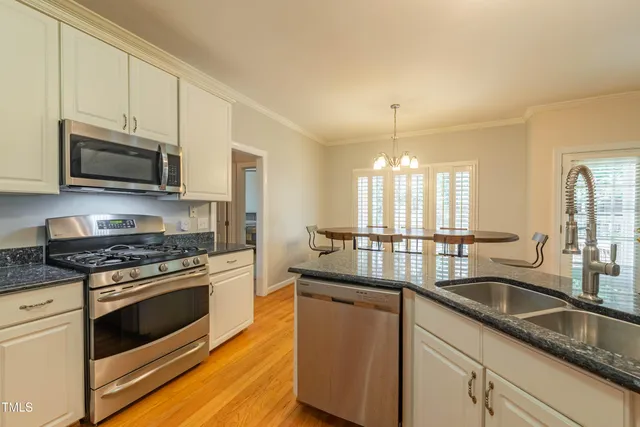 a kitchen with granite countertop a sink stainless steel appliances and cabinets