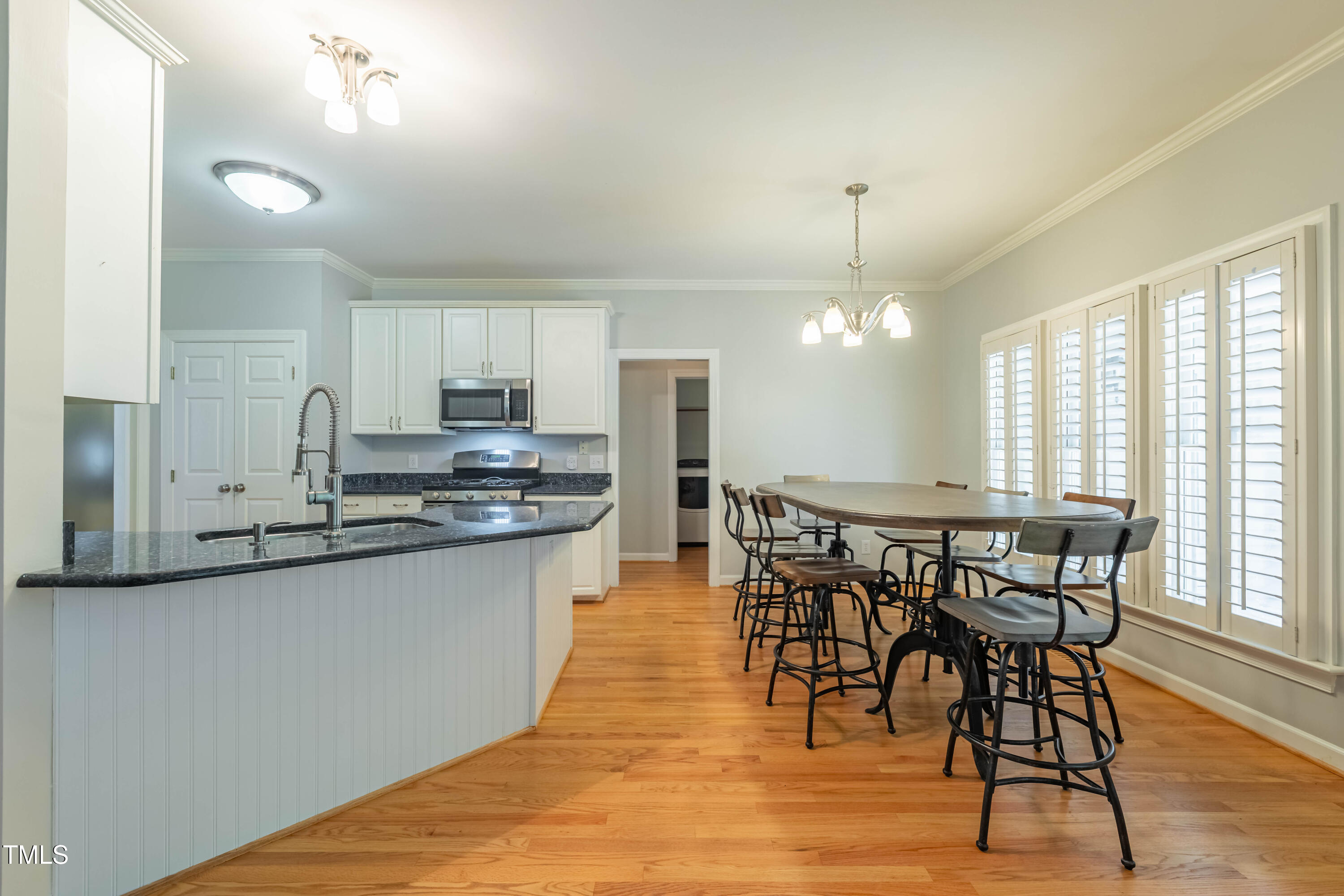 3009 Walton Heath Court Raleigh, NC 27612 - Photo 17 of 40 a kitchen with stainless steel appliances granite countertop wooden floor dining table and chairs