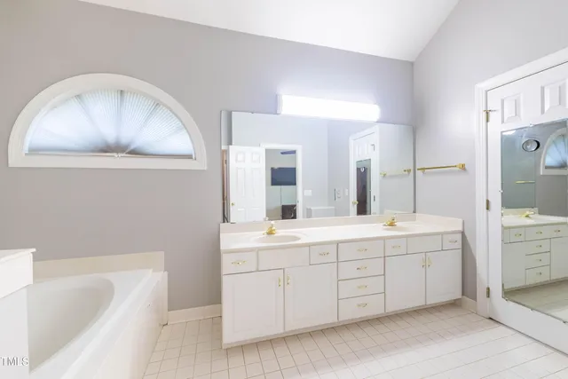 a bathroom with a sink a large mirror and a bathtub