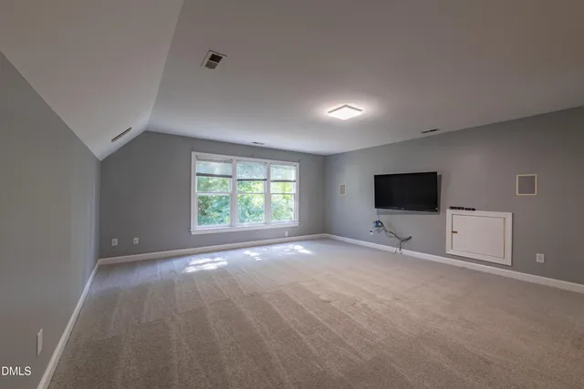 an empty room with windows and tv