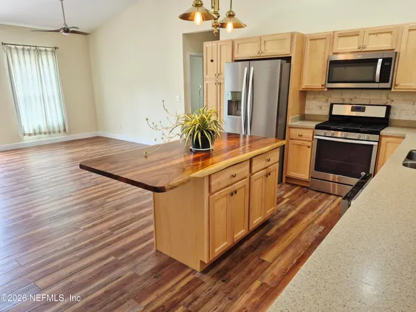 a kitchen with stainless steel appliances granite countertop a refrigerator a stove and a sink