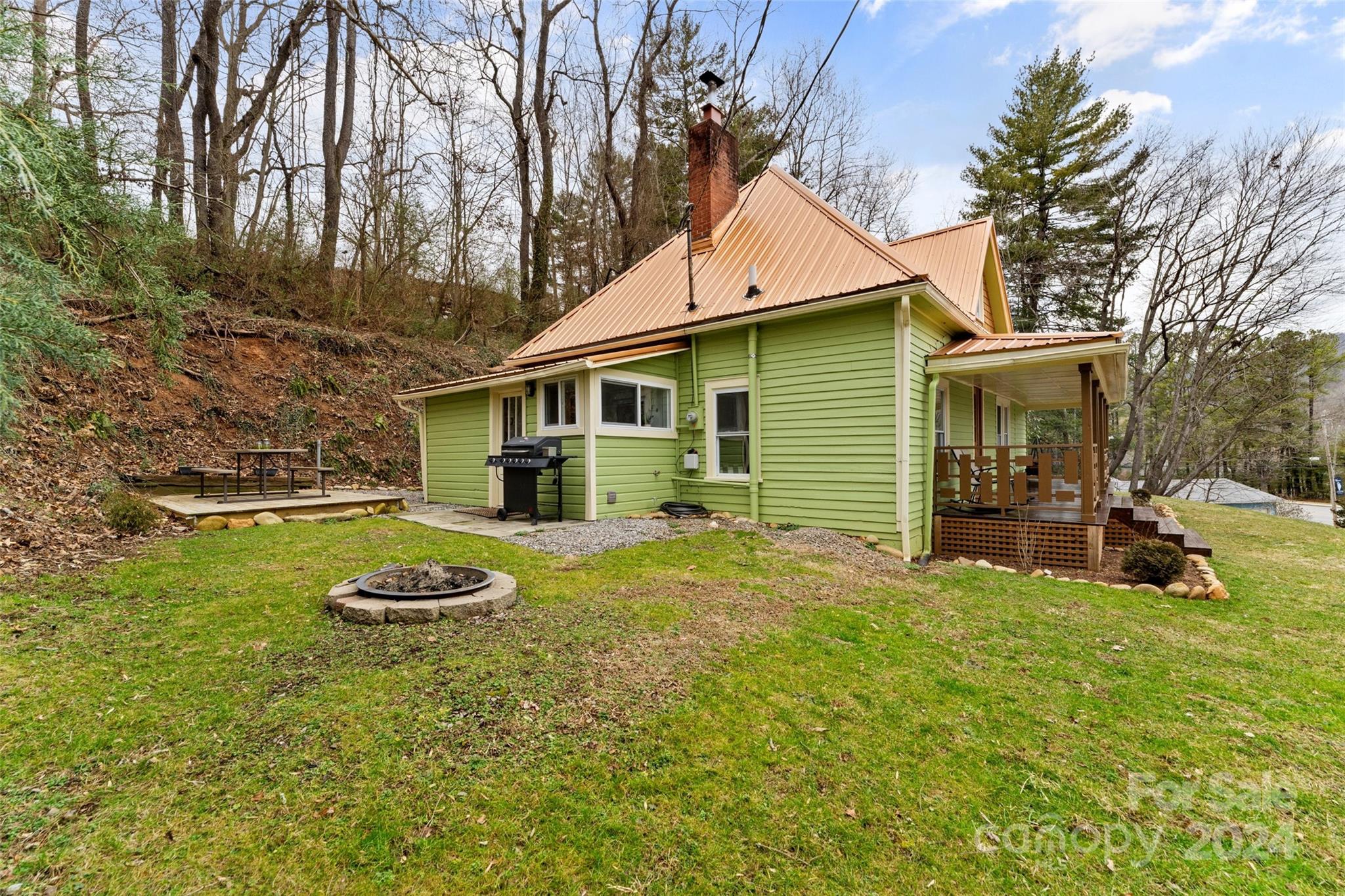 24 Brookside Street Clyde, NC 28721 - Photo 29 of 40 a view of a white house with a yard and sitting area