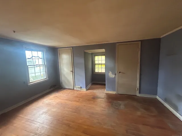 an empty room with windows and closet