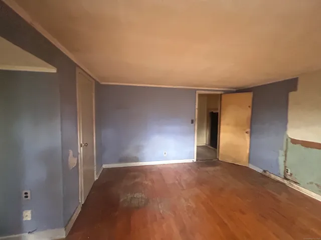 a view of an empty room with window and wooden floor
