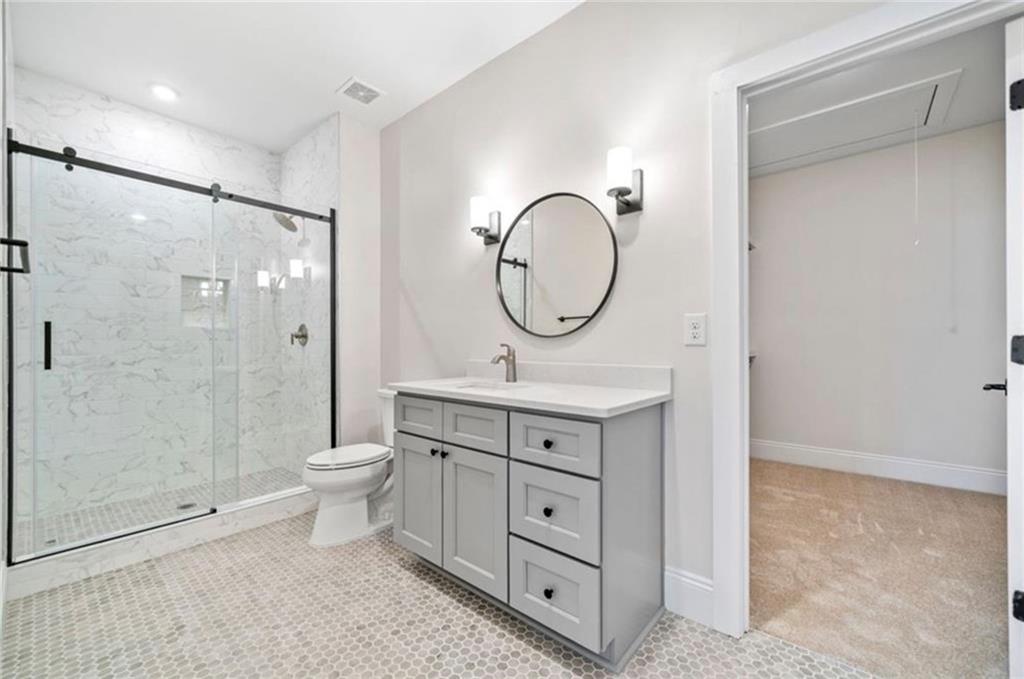 310 Timberview Trail Alpharetta, GA 30004 - Photo 46 of 71 a bathroom with a toilet a sink a mirror and a shower