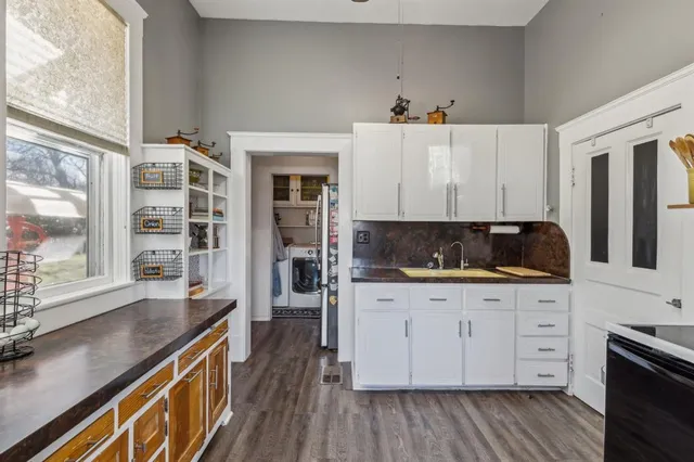 a kitchen with granite countertop a sink cabinets and wooden floor