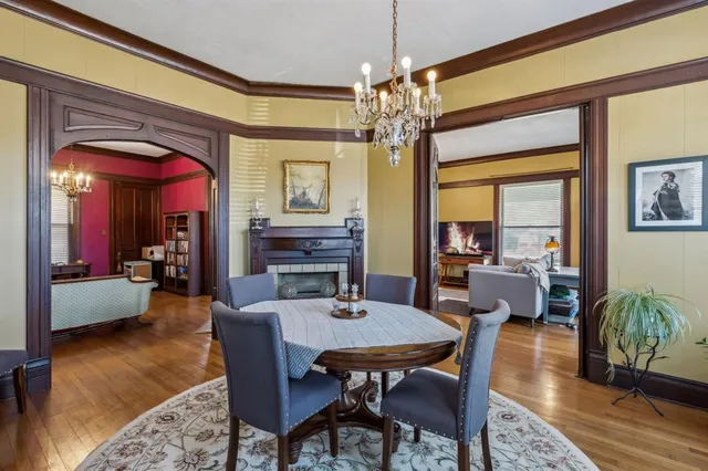 a view of a dining room with furniture a chandelier and wooden floor