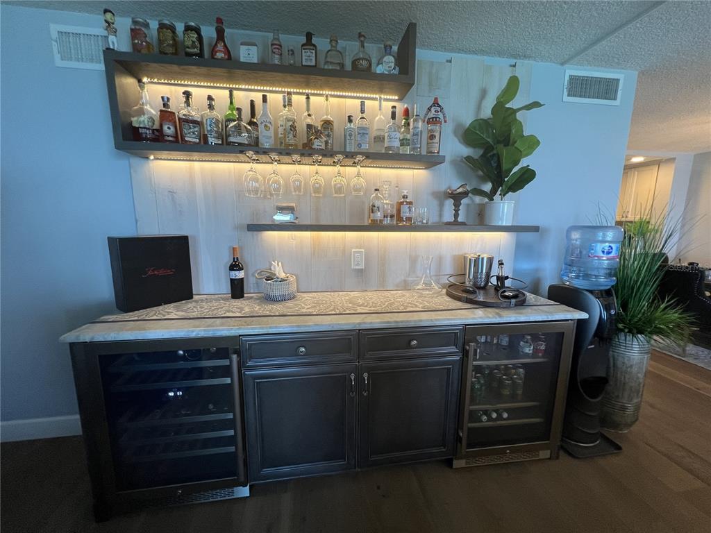 7100 Sunset Way, Unit PH5 St. Pete Beach, FL 33706 - Photo 15 of 32 a view of cabinets a wooden floor and a potted plant