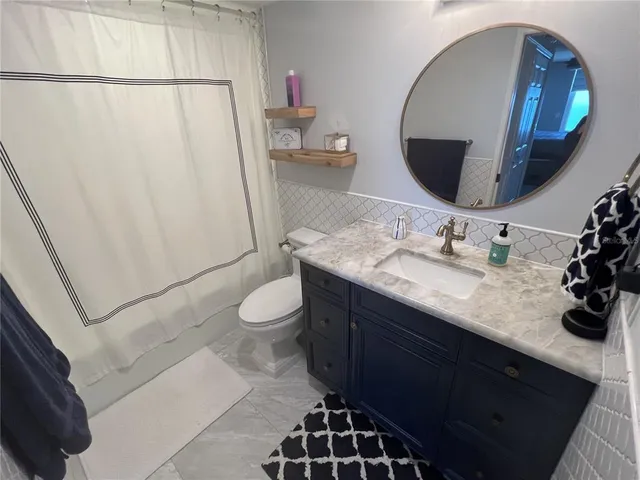 a large bed sitting in a bedroom next to a window and a lamp