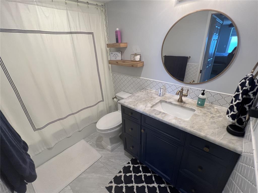 7100 Sunset Way, Unit PH5 St. Pete Beach, FL 33706 - Photo 18 of 32 a bathroom with a double vanity sink toilet and mirror