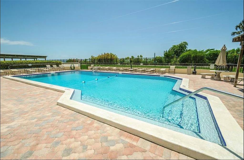 7100 Sunset Way, Unit PH5 St. Pete Beach, FL 33706 - Photo 22 of 32 a view of a swimming pool and an outdoor seating