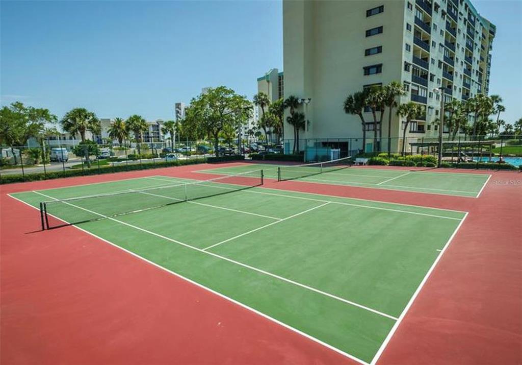 7100 Sunset Way, Unit PH5 St. Pete Beach, FL 33706 - Photo 30 of 32 a tennis court that has tall trees in front of it